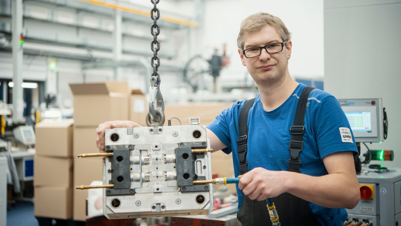 Ein junger Mann arbeitet an einem technischen Modell