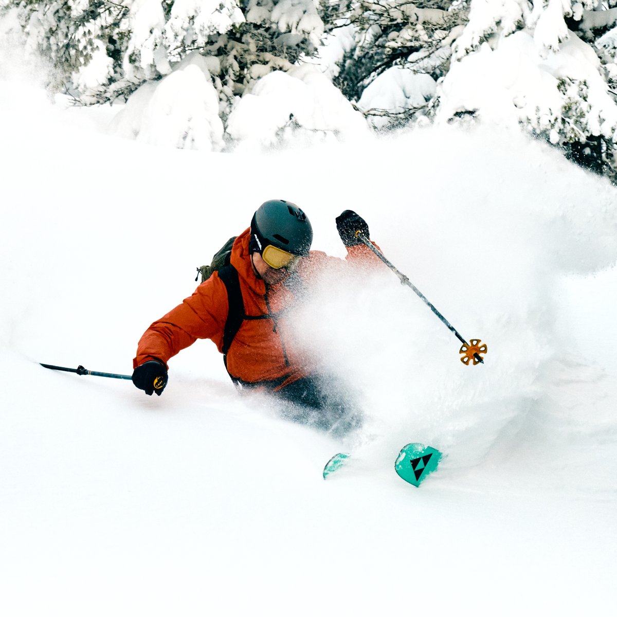 Ein Skifahrer im Tiefschnee, der gerade eine Kurve fährt