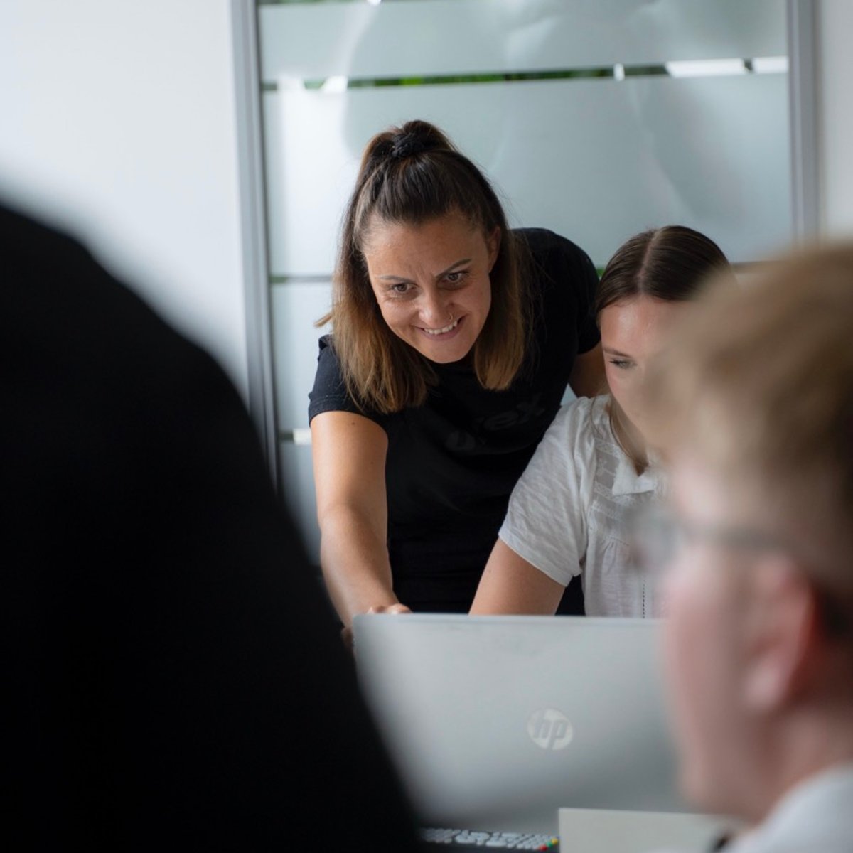 Eine Frau zeigt einer anderen Frau etwas am Laptop
