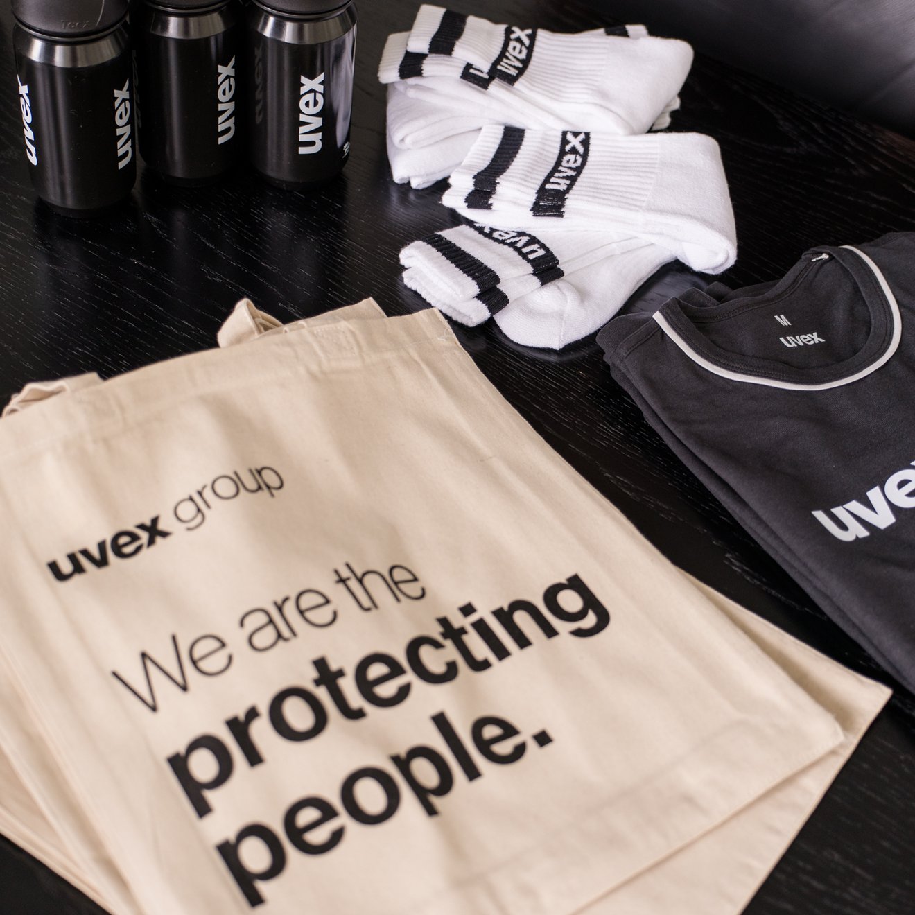 Mehrere Artikel von uvex, darunter eine Tote Bag ein T-Shirt, Socken und Trinkflaschen