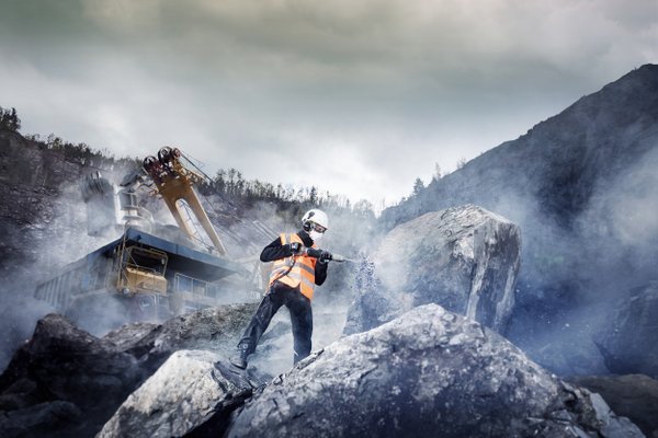 Eine Person in Sicherheitskleidung steht in den Bergen