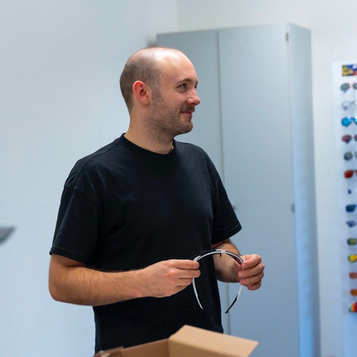 Ein uvex Werkstudent hält eine Radbrille in den Händen