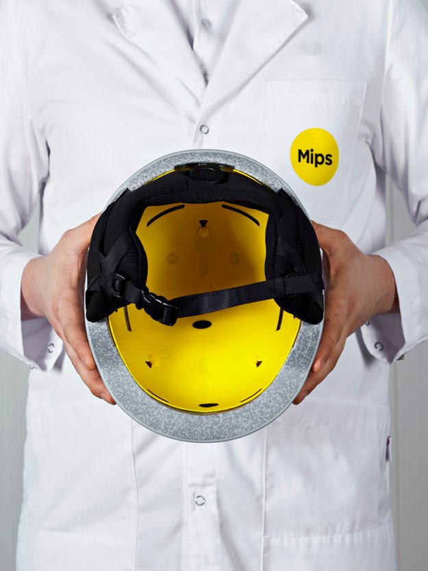 Eine Person hält einen gelben Skihelm in den Händen