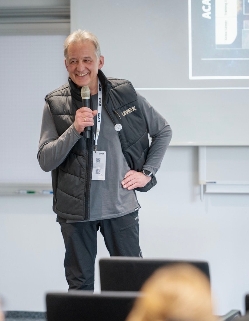 Dr. Thomas Fröhlich, hält einen Vortrag und lächelt.