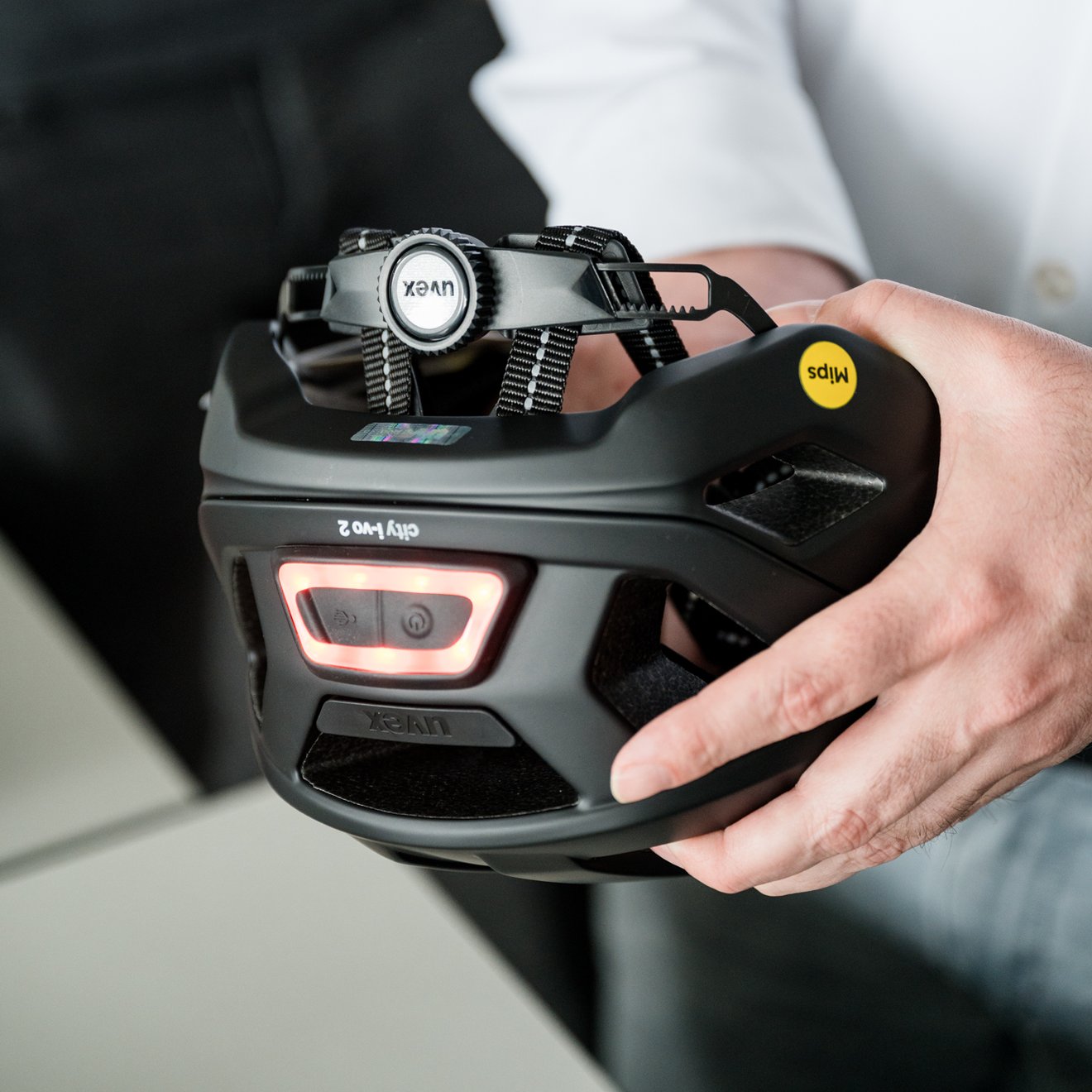 Schwarzer Radhelm mit Licht in einer Hand