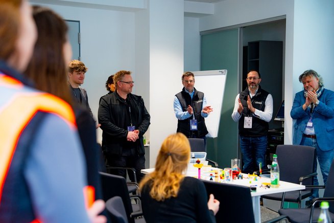 Eine Gruppe an Personen klatscht nach einem Vortrag