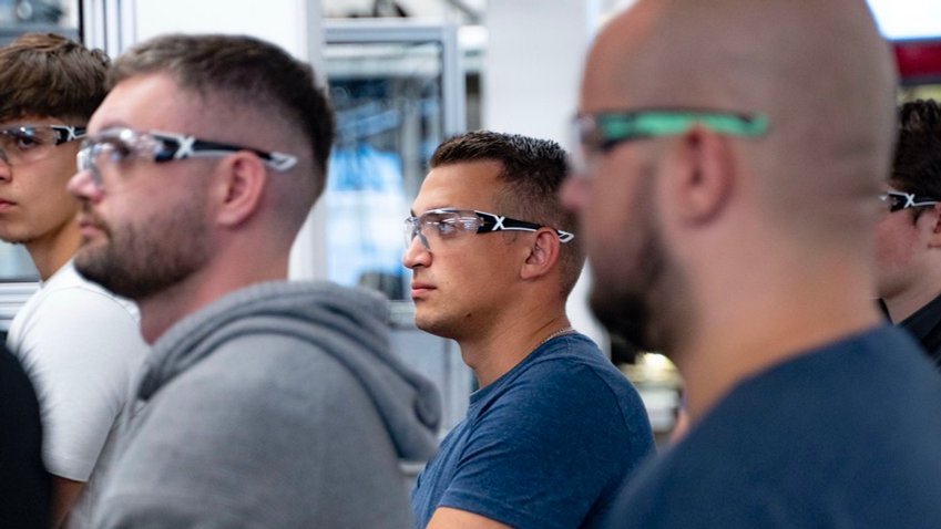 mehrere Azubis der uvex group, alle mit Sicherheitsbrillen ausgerüstet