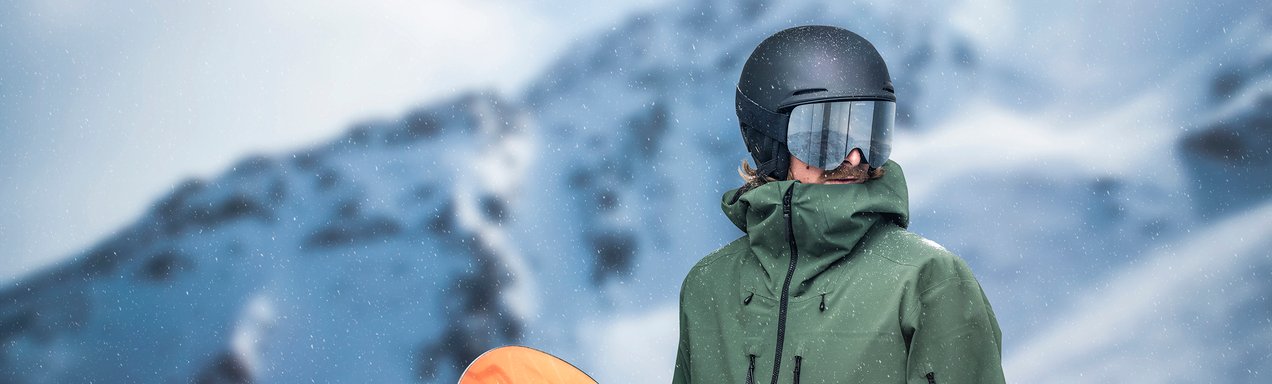 Eine Person mit Skihelm und Skibrille in den Bergen