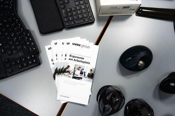 Broschüre zum Thema Ergonomieberatung liegen auf einem Schreibtisch.