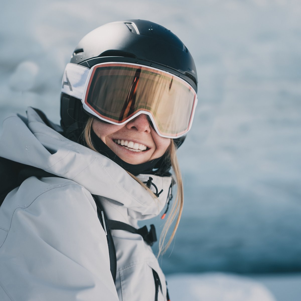 A woman wearing a uvex ski helmet and ski goggles