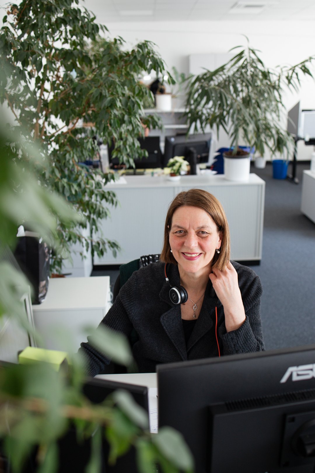 Frau Roos sitzt an ihrem Schreibtisch im Büro