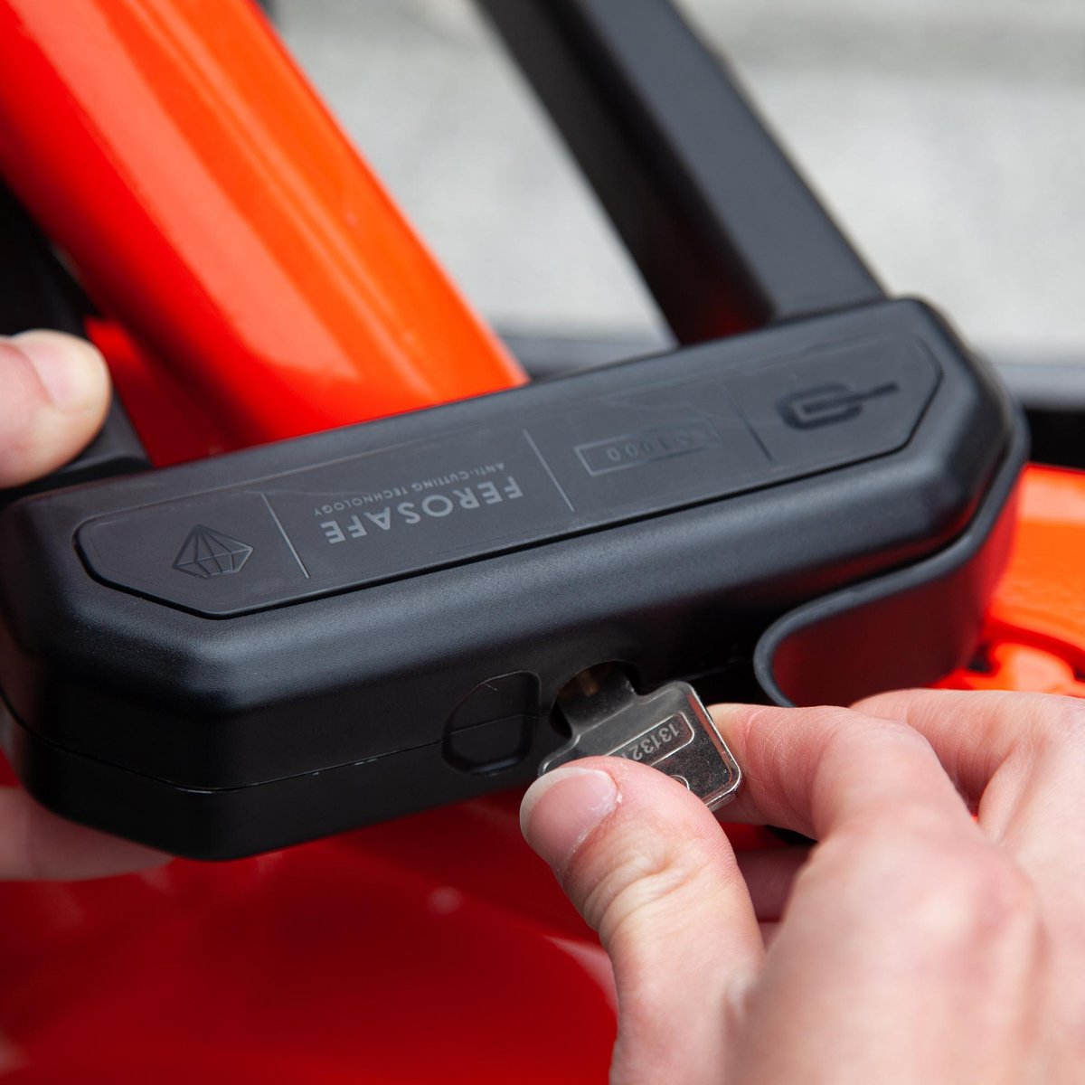 Detailaufnahme einer Person die ein Schloss abschließt