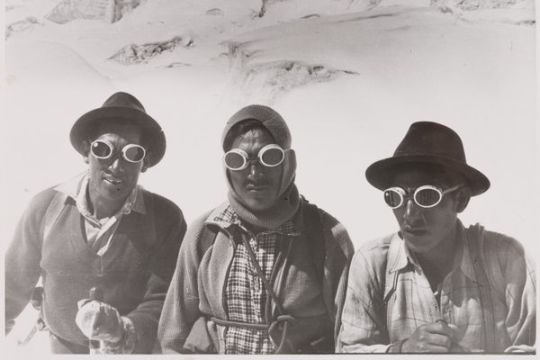 Drei Personen mit Gletscherschutzbrillen auf einem verschneiten Berg