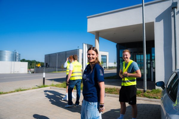 Eine Auszubildende steht vor dem Logistikgebäude uvex Rednitzhembach