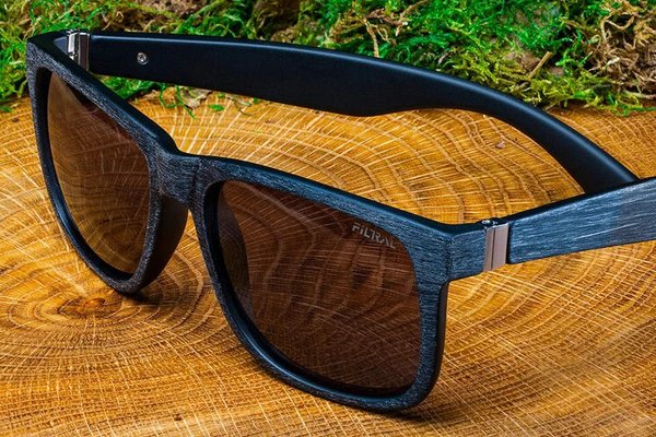 Eine blaue Sonnenbrille auf einem Baumstumpf