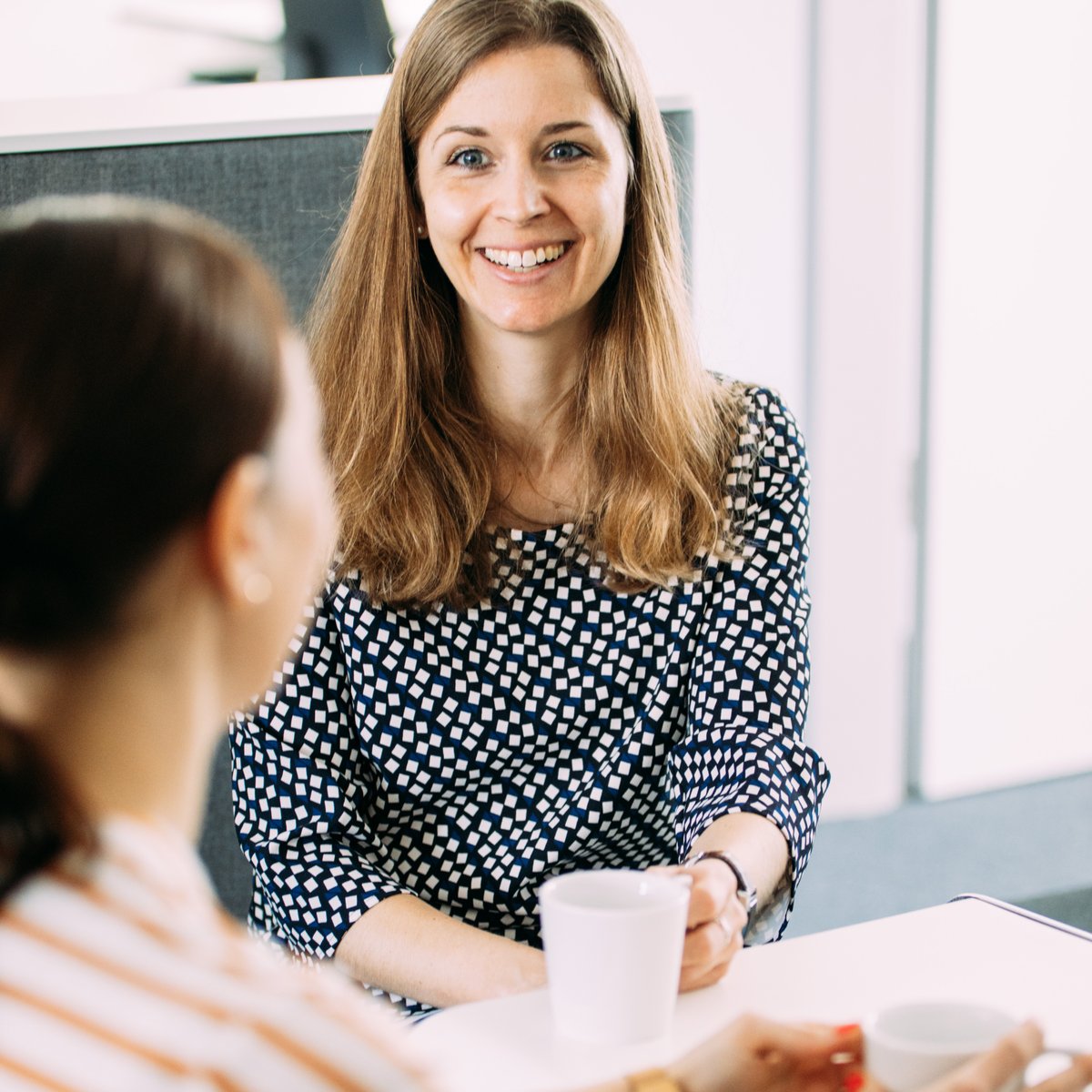 Zwei Frauen lachen am Arbeitsplatz