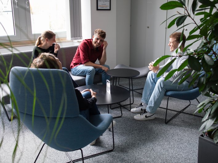 Ein Teammeting in einer Wohnzimmer-ähnlichen Umgebung