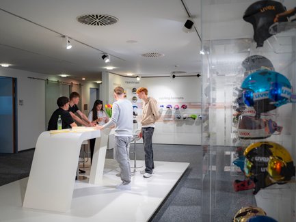 Einige Personen stehen um einen Tisch versammelt