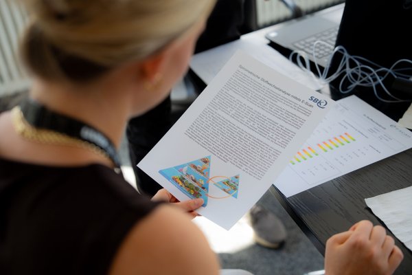 Eine uvex Mitarbeiterin schaut sich ein Infoblatt zum Thema Ernährung an.