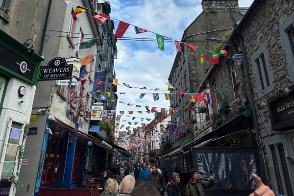 Blick in eine alte Straße in einer Stadt. Zwischen den Dächern sind Girlanden gespannt
