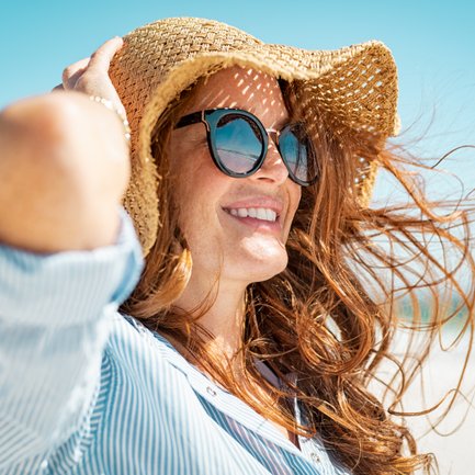 Ein Frau mit Hut und Sonnenbrille