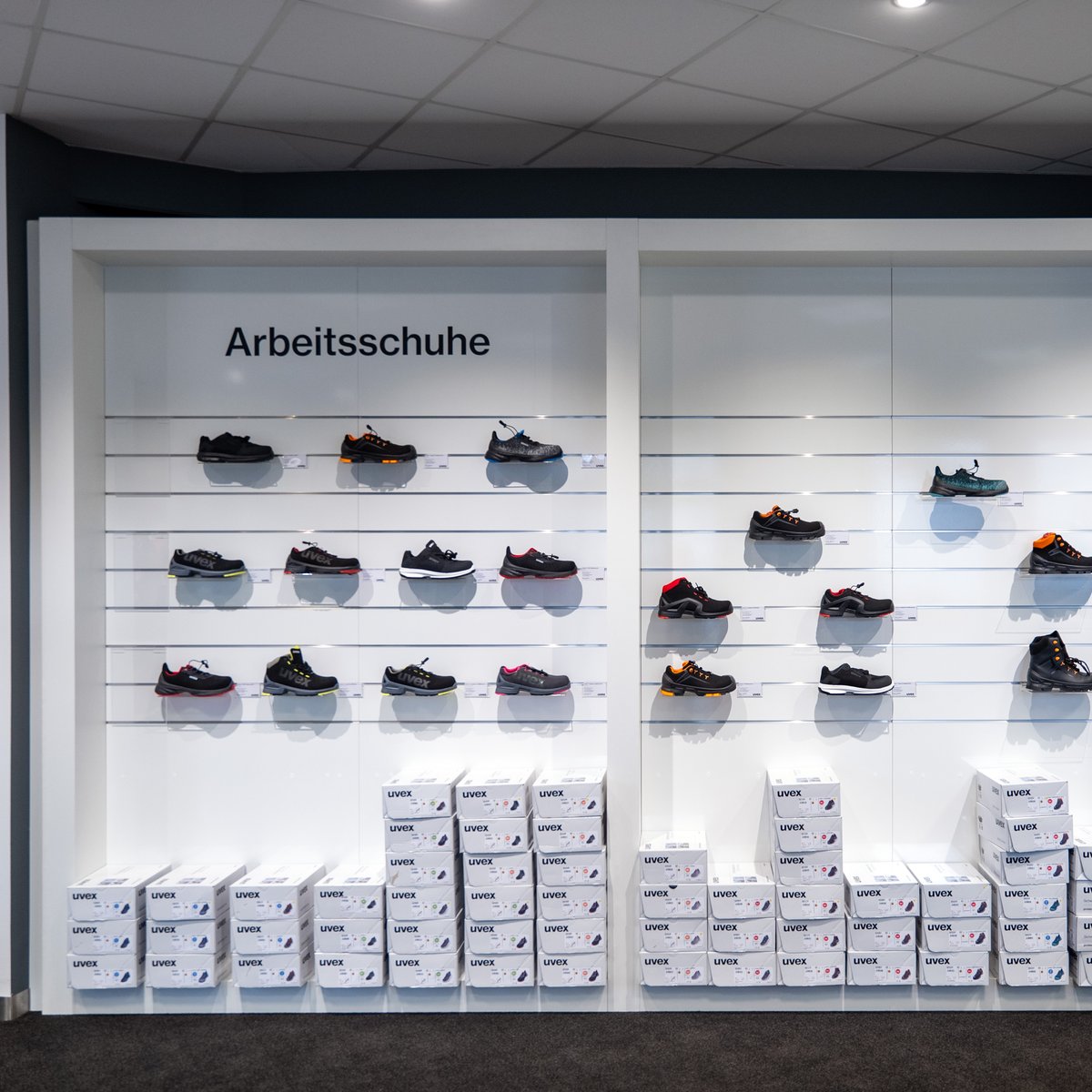 Eine Wand an der Sicherheitsschuhe ausgestellt sind