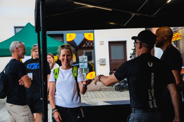 Eine Frau lächelnd am Stand von uvex bei der Challenge Roth